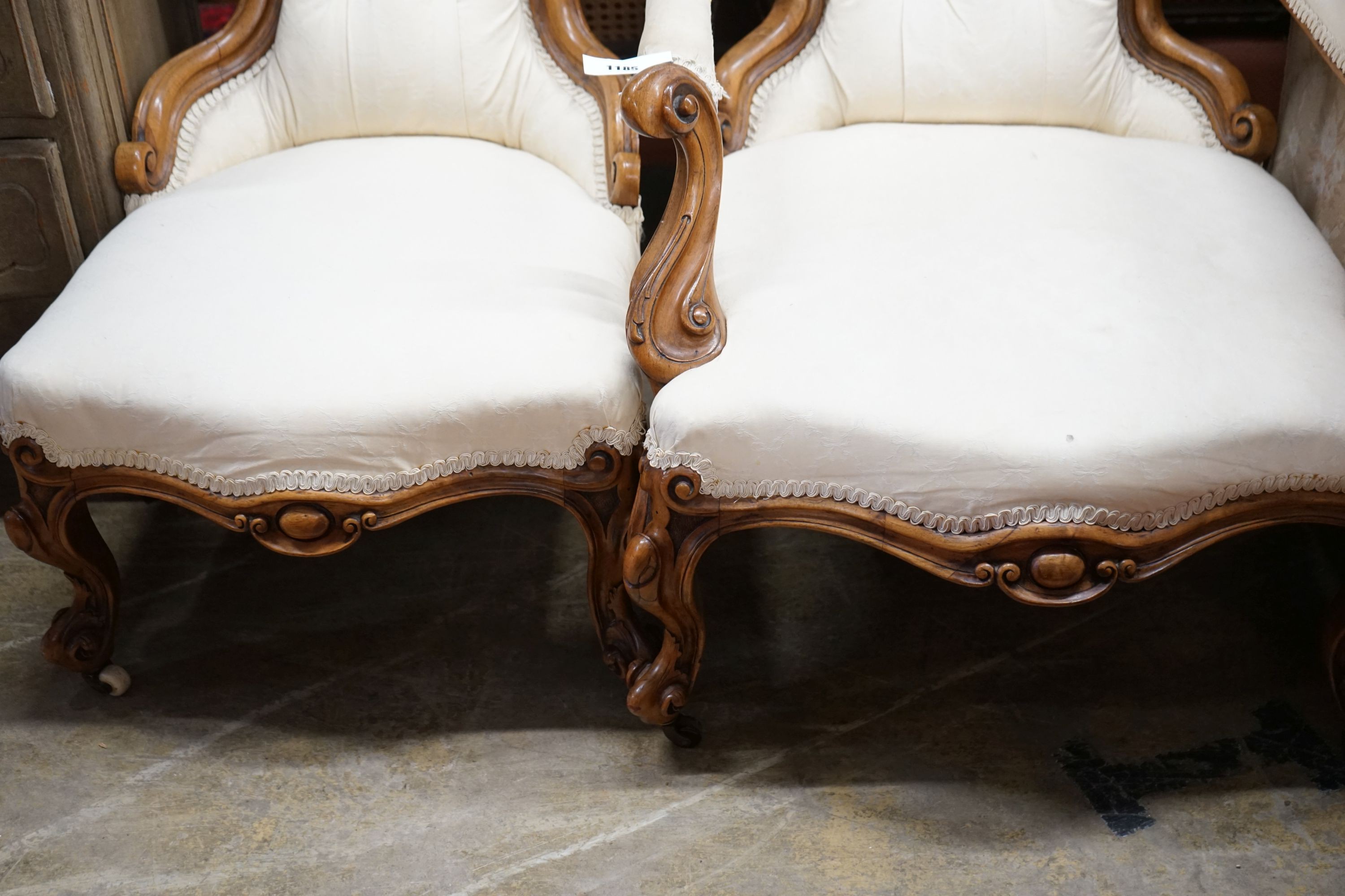 A pair of Victorian carved walnut chairs, one with arms